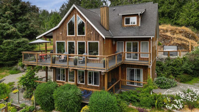 Large cabin with peaked roof, large deck and lots of windows located in Sooke BC