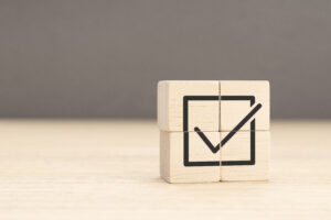 Corporate regulatory and compliance. Goals achievement and business success. Task completion. Wooden cube with check mark icon. Copy space
