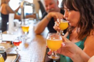 Group of Friends Enjoying Glasses of Micro Brew Beer At Bar.