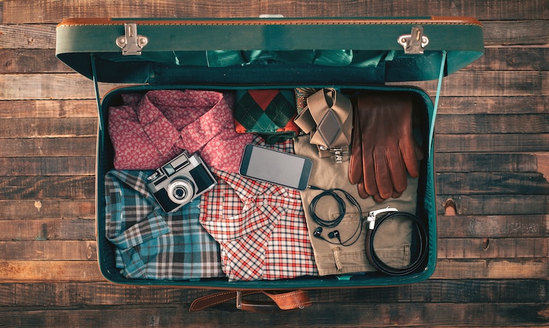 suitcase packed with fall clothes, camera - fall adventure travel
