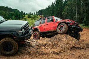 red and black 4x4 vehicles parked near a forest
