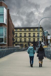 two women walking along the foot bridge toward downtown Victoria