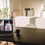 Laptop on table with a video call on the screen in living room. People using VoIP to connect together.