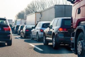 Cars and trucks are stuck in a traffic jam on a highway, creating congestion and delays for commuters