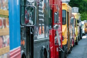Parked and lined up street food trucks. Selective focus and vintage style.